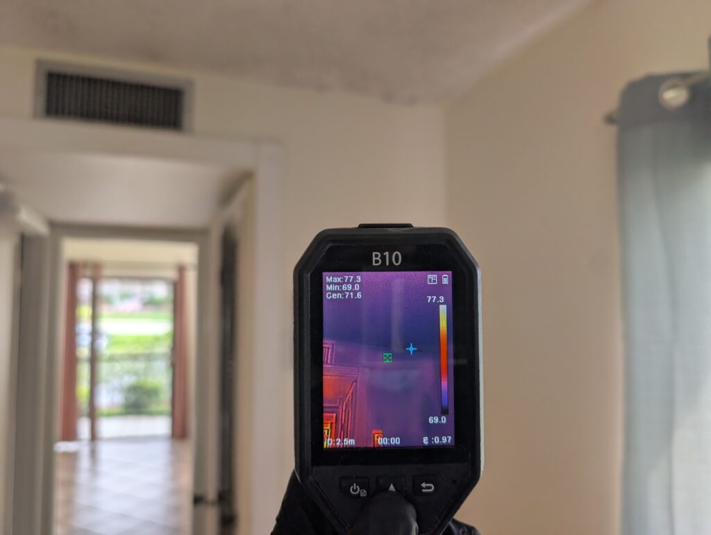 Thermal imaging camera detecting hidden moisture inside walls during water damage inspection in Palm Beach County
