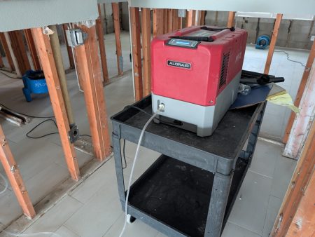 LGR dehumidifier drying exposed wall studs after water damage remediation