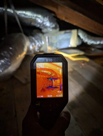 thermal camera detecting hidden moisture near ductwork during water damage inspection