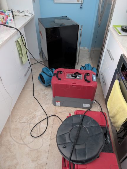 Dehumidifier and air movers drying water damage in Palm Beach County Kitchen