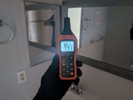 Moisture and humidity readings being taken inside a bathroom during water damage inspection in Palm Beach County